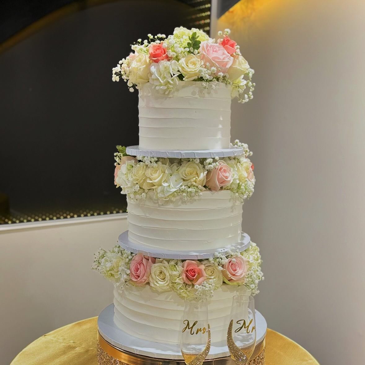 Three-tier cake with fresh flowers at Tarzana Bakery